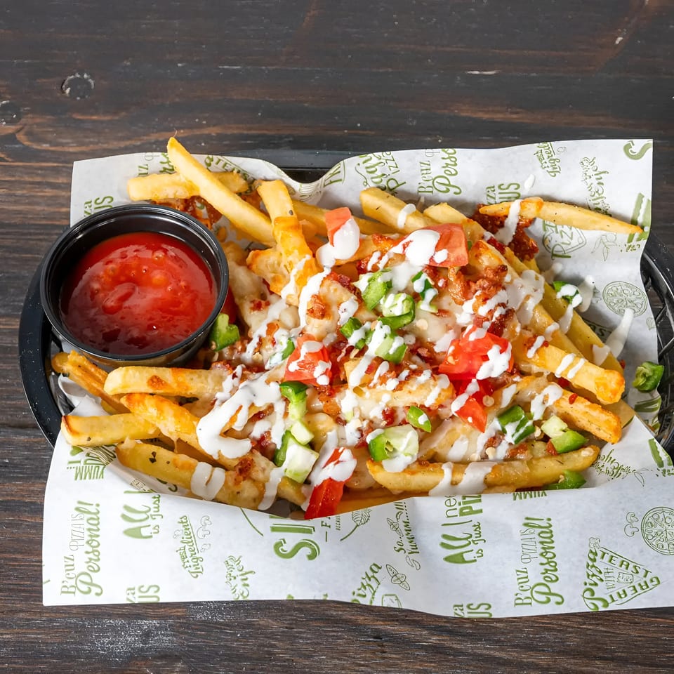 Loaded fries with melted cheese, bacon, diced tomatoes, jalapeños, and a side of ketchup.