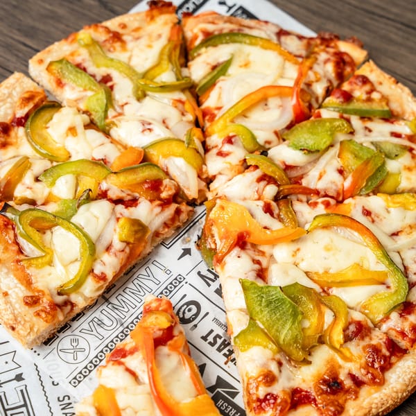 Singas Famous Pizza's sliced vegetable pizza with melted cheese, green and yellow bell peppers, and onions.