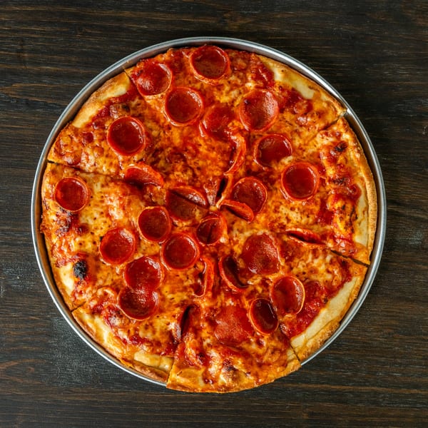 A whole pepperoni pizza from Singas Famous Pizza, sliced and ready to eat.