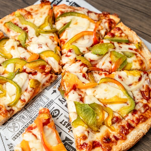 A whole Singas Famous Pizza, sliced, topped with melted cheese, green and orange bell peppers, and onions.
