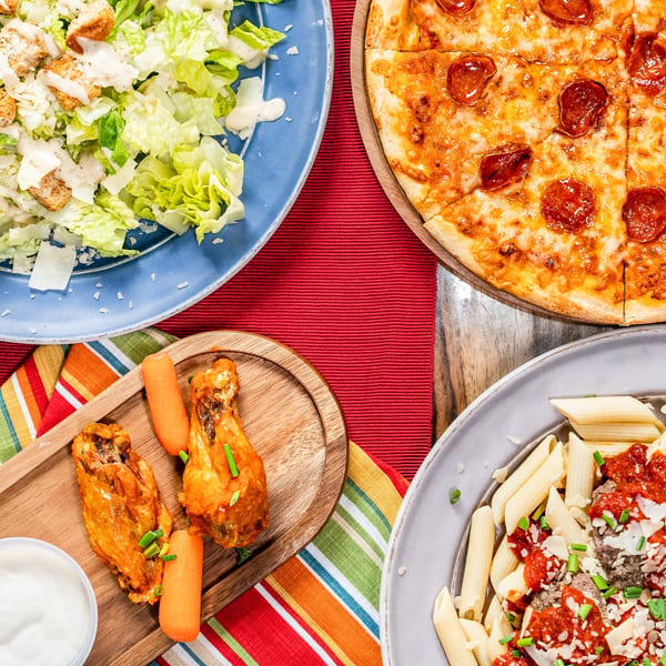 Singas Famous Pizza pepperoni pizza, Caesar salad, buffalo wings, and penne pasta with meatballs.