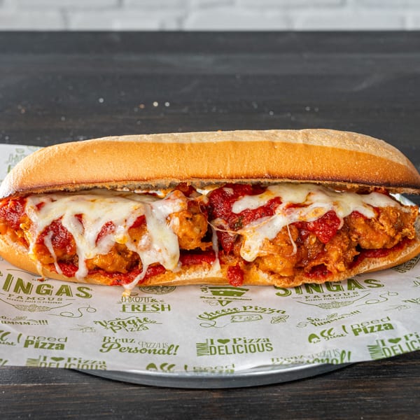 A chicken parmesan hero sandwich with melted mozzarella and marinara sauce on branded paper.