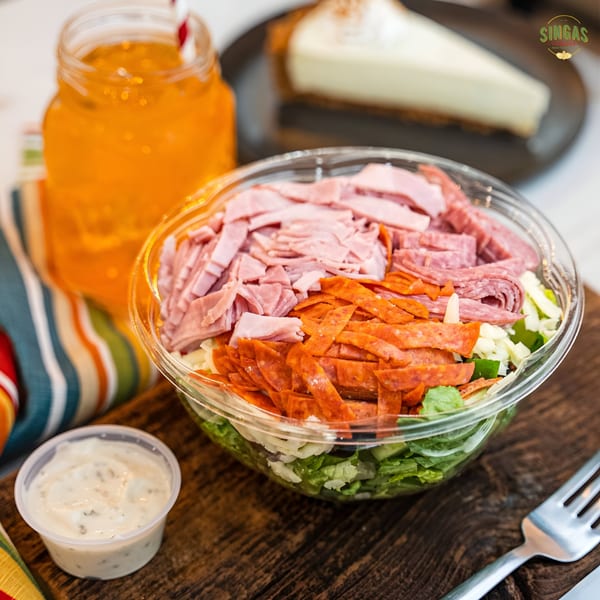 Singas Famous Pizza's chef salad with ham, pepperoni, and salami, a drink, and cheesecake.